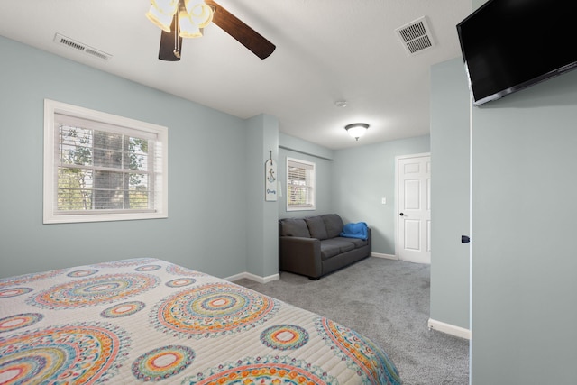 carpeted bedroom featuring ceiling fan and multiple windows