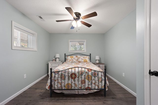 bedroom with ceiling fan, dark hardwood / wood-style floors, and multiple windows