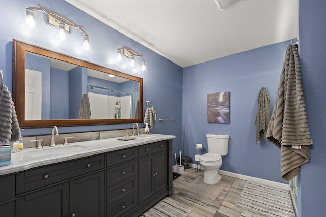 bathroom featuring vanity, a textured ceiling, toilet, and an enclosed shower