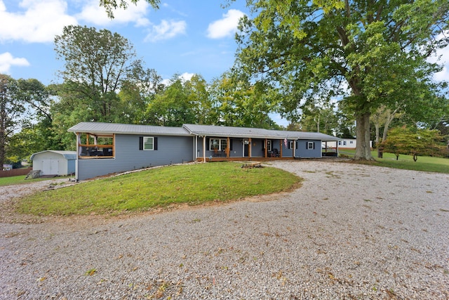 single story home featuring a storage shed, covered porch, and a front yard