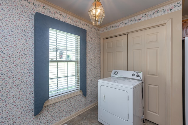 clothes washing area with washer / clothes dryer, ornamental molding, and a notable chandelier