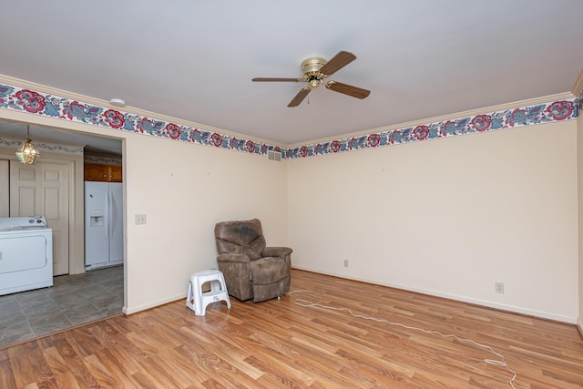 unfurnished room with washer / clothes dryer, ornamental molding, and light hardwood / wood-style flooring