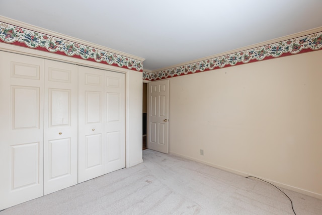 unfurnished bedroom featuring light colored carpet, a closet, and crown molding