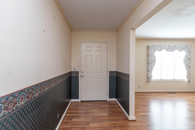 doorway featuring ornamental molding and hardwood / wood-style floors