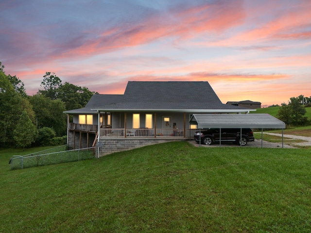 view of front of home with a yard, covered porch, and a carport