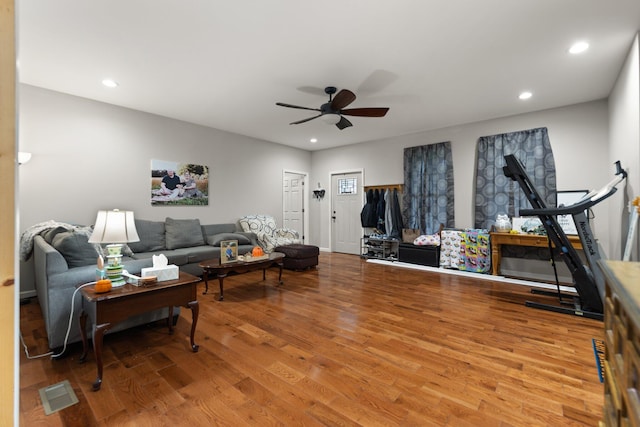 living room featuring wood-type flooring and ceiling fan