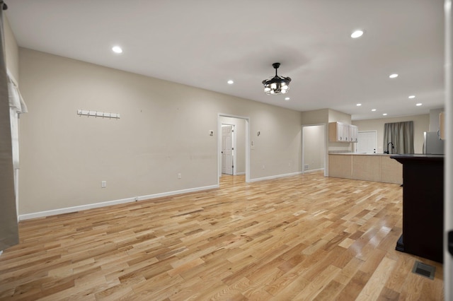 unfurnished living room featuring light hardwood / wood-style floors and sink