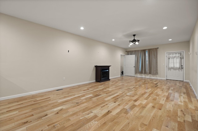 unfurnished living room featuring ceiling fan and light hardwood / wood-style floors