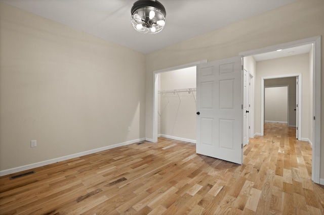 unfurnished bedroom with light wood-type flooring and a closet