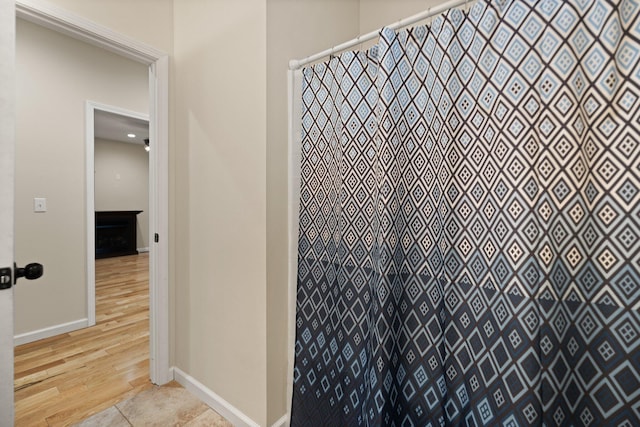 bathroom with a shower with shower curtain and tile patterned flooring