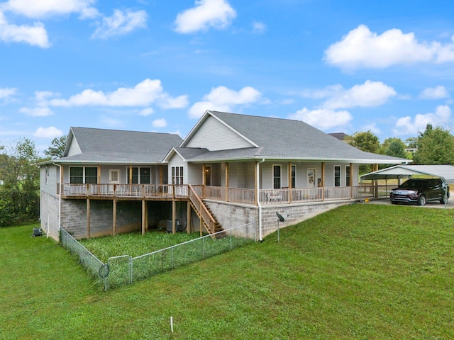 rear view of house featuring a lawn, covered porch, and a carport