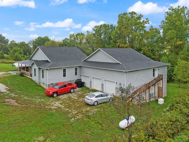 back of house with a lawn and a garage