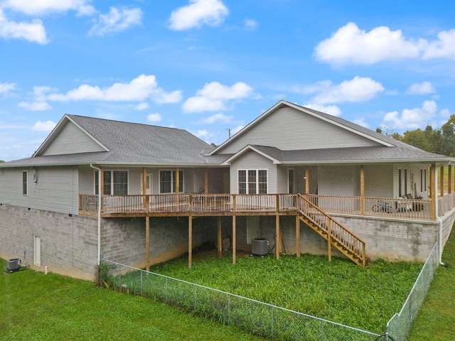 rear view of property featuring a yard, cooling unit, and a wooden deck