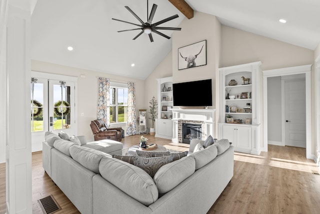 living room featuring light hardwood / wood-style flooring, beam ceiling, high vaulted ceiling, and ceiling fan