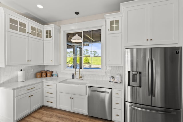 kitchen with decorative backsplash, white cabinets, stainless steel appliances, and sink