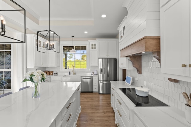 kitchen with appliances with stainless steel finishes, light stone counters, and white cabinets