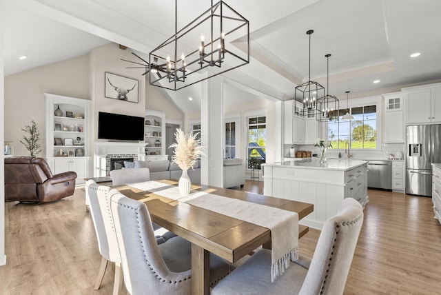 dining space featuring vaulted ceiling and light hardwood / wood-style flooring