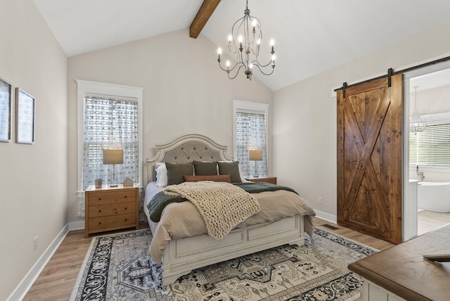 bedroom featuring a barn door, ensuite bath, lofted ceiling with beams, light hardwood / wood-style floors, and a notable chandelier