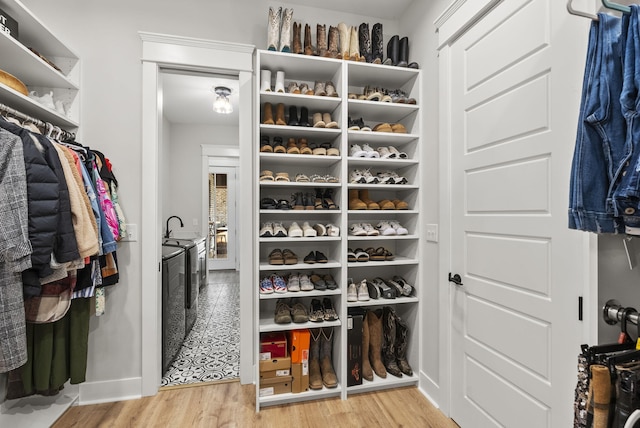 spacious closet featuring sink, light hardwood / wood-style flooring, and separate washer and dryer