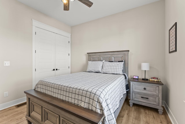 bedroom with a closet, light hardwood / wood-style floors, and ceiling fan