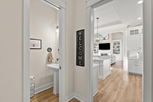 corridor featuring light hardwood / wood-style flooring and a notable chandelier