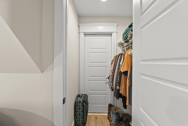 walk in closet with light hardwood / wood-style floors