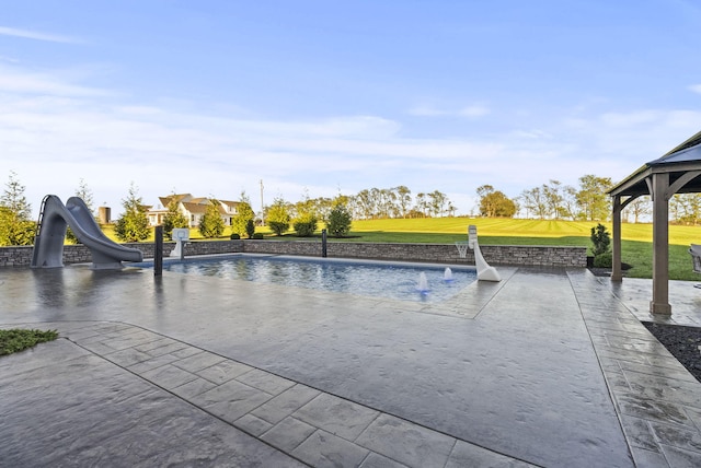 view of swimming pool with a water slide, a patio area, a gazebo, pool water feature, and a lawn