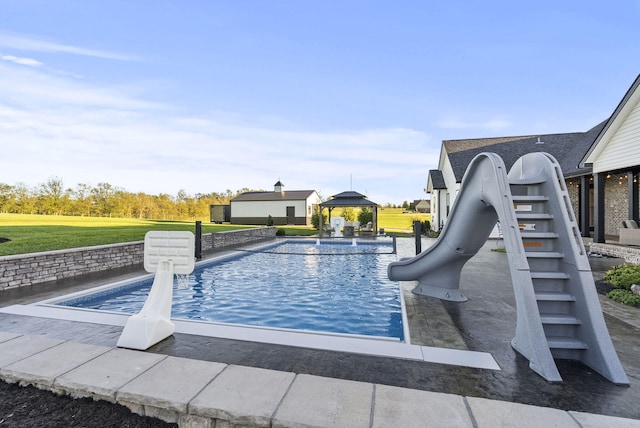 view of swimming pool featuring a gazebo, a water slide, and a patio area