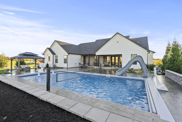 view of swimming pool with a gazebo, a water slide, and a patio