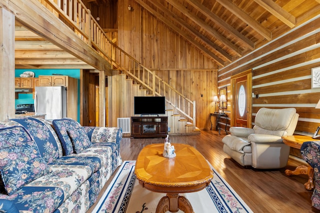 living room featuring high vaulted ceiling, wood walls, beamed ceiling, wooden ceiling, and hardwood / wood-style flooring