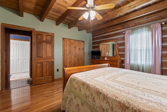 bedroom with ceiling fan, beamed ceiling, hardwood / wood-style flooring, and wood ceiling