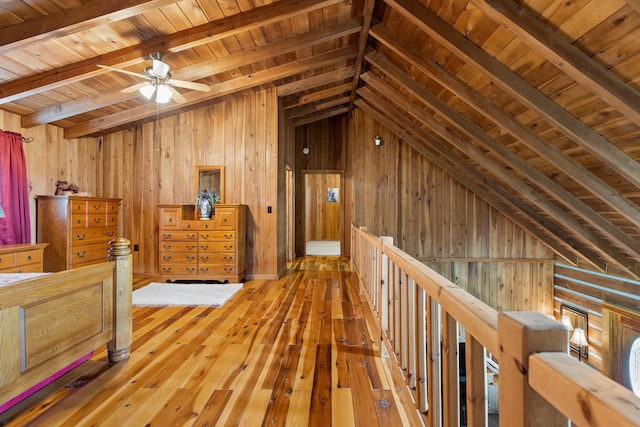 interior space with wooden walls, lofted ceiling with beams, hardwood / wood-style floors, and wooden ceiling