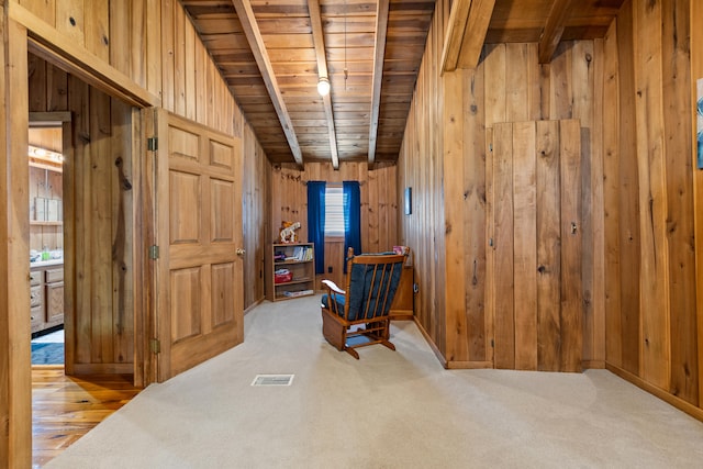 interior space featuring light carpet, wood walls, track lighting, and wooden ceiling