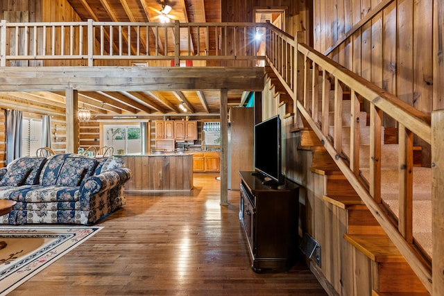 living room featuring light wood-type flooring, beam ceiling, wooden ceiling, and wooden walls