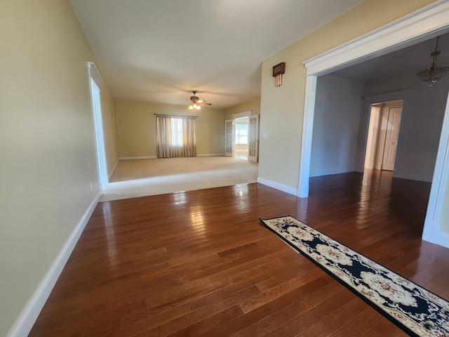 unfurnished room with ceiling fan and dark wood-type flooring