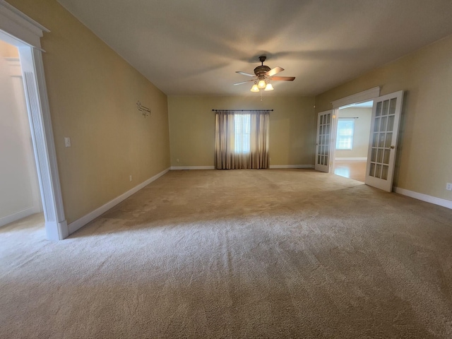 carpeted empty room featuring ceiling fan and french doors