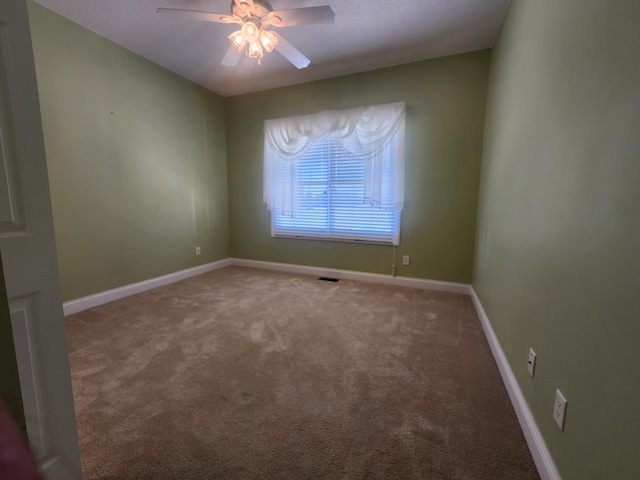 spare room featuring ceiling fan and carpet floors