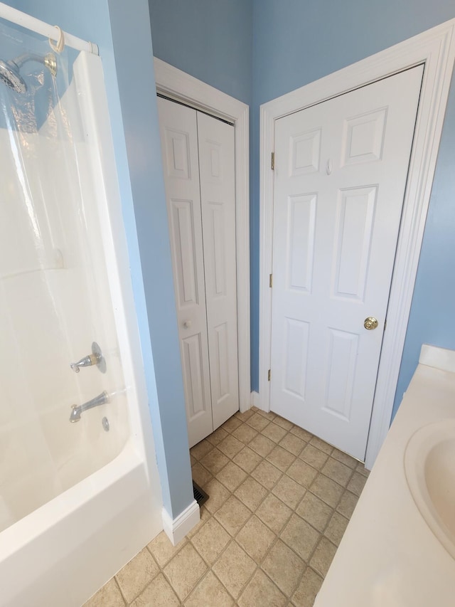 bathroom with tile patterned flooring, washtub / shower combination, and vanity