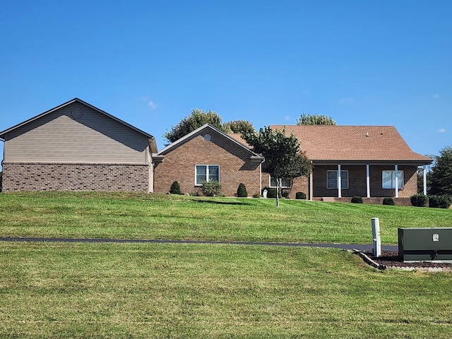 rear view of property featuring a lawn