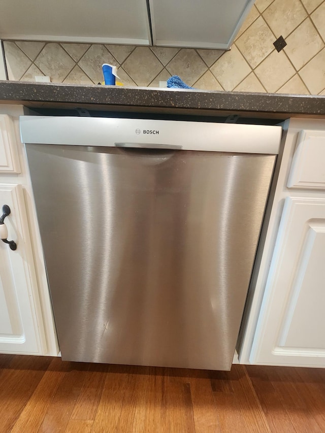 interior details featuring dishwasher, light hardwood / wood-style floors, and white cabinetry