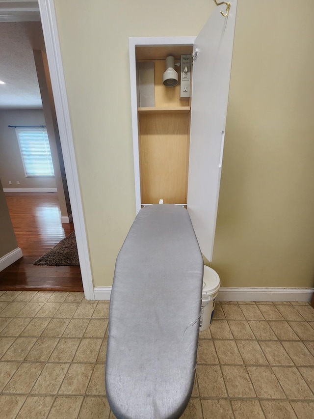 interior space with a textured ceiling, hardwood / wood-style floors, and toilet