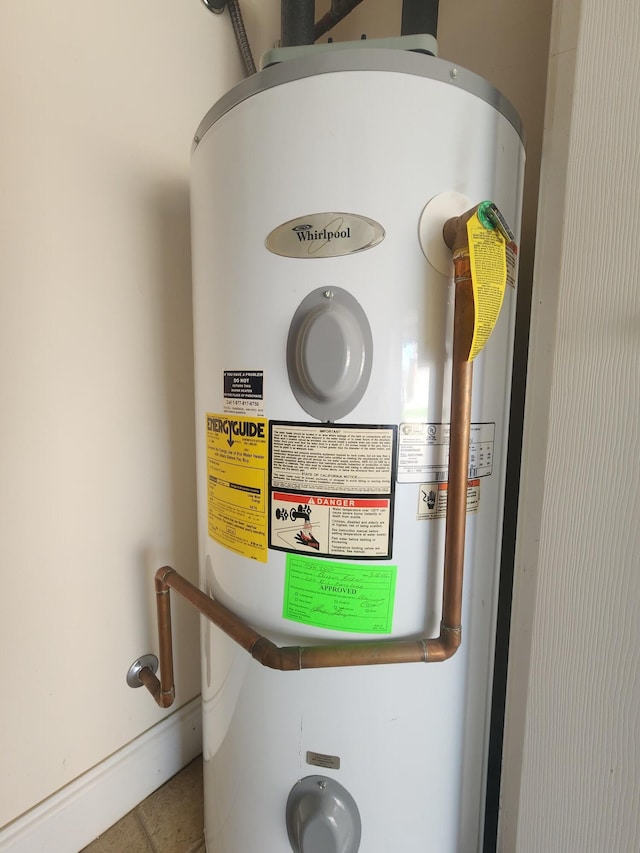 room details with electric water heater and tile patterned floors