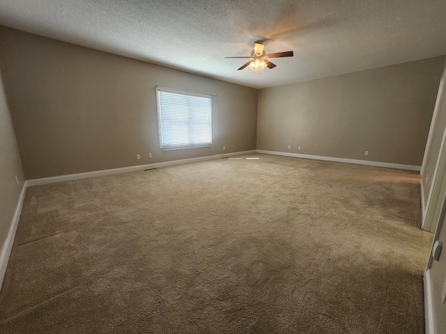 spare room with a textured ceiling, carpet, and ceiling fan