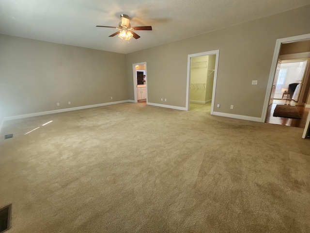 spare room with ceiling fan and light colored carpet