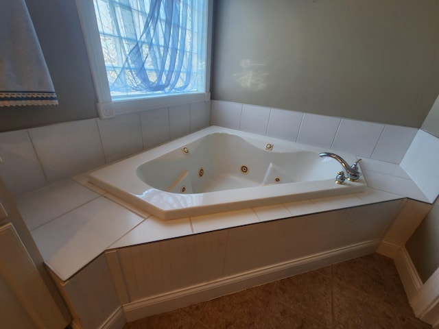 bathroom featuring a relaxing tiled tub and tile patterned flooring