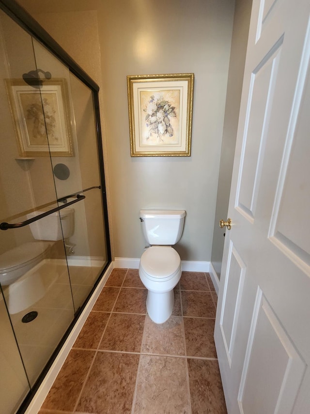 bathroom with a shower with door, toilet, and tile patterned floors