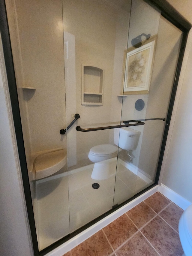 bathroom with walk in shower, tile patterned floors, and toilet