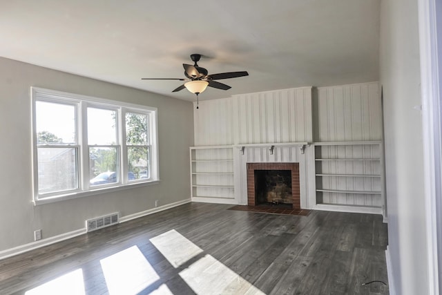 unfurnished living room with dark hardwood / wood-style floors, ceiling fan, and a fireplace