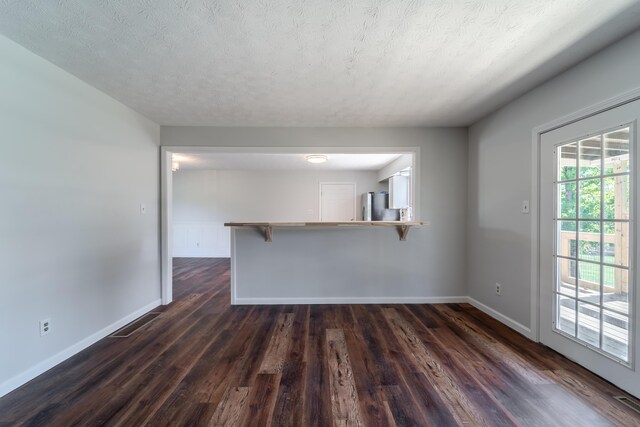 empty room featuring dark wood-type flooring and a textured ceiling