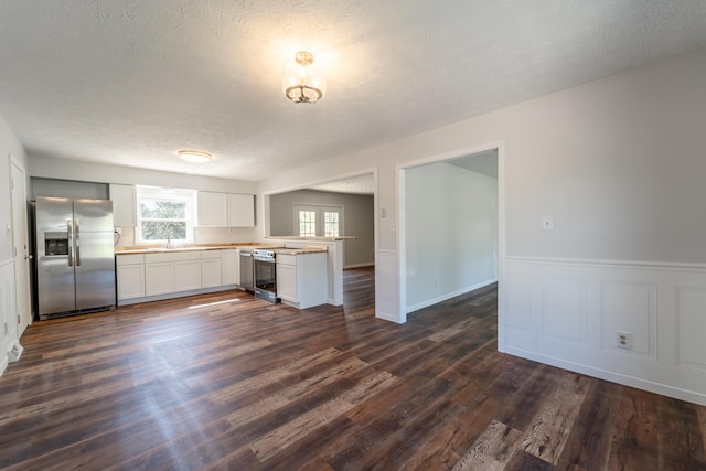 kitchen featuring white cabinets, sink, dark hardwood / wood-style flooring, appliances with stainless steel finishes, and a textured ceiling